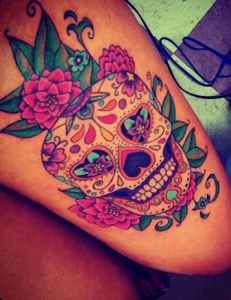 Tatuaggio colorato di un teschio messicano con fiori rosa